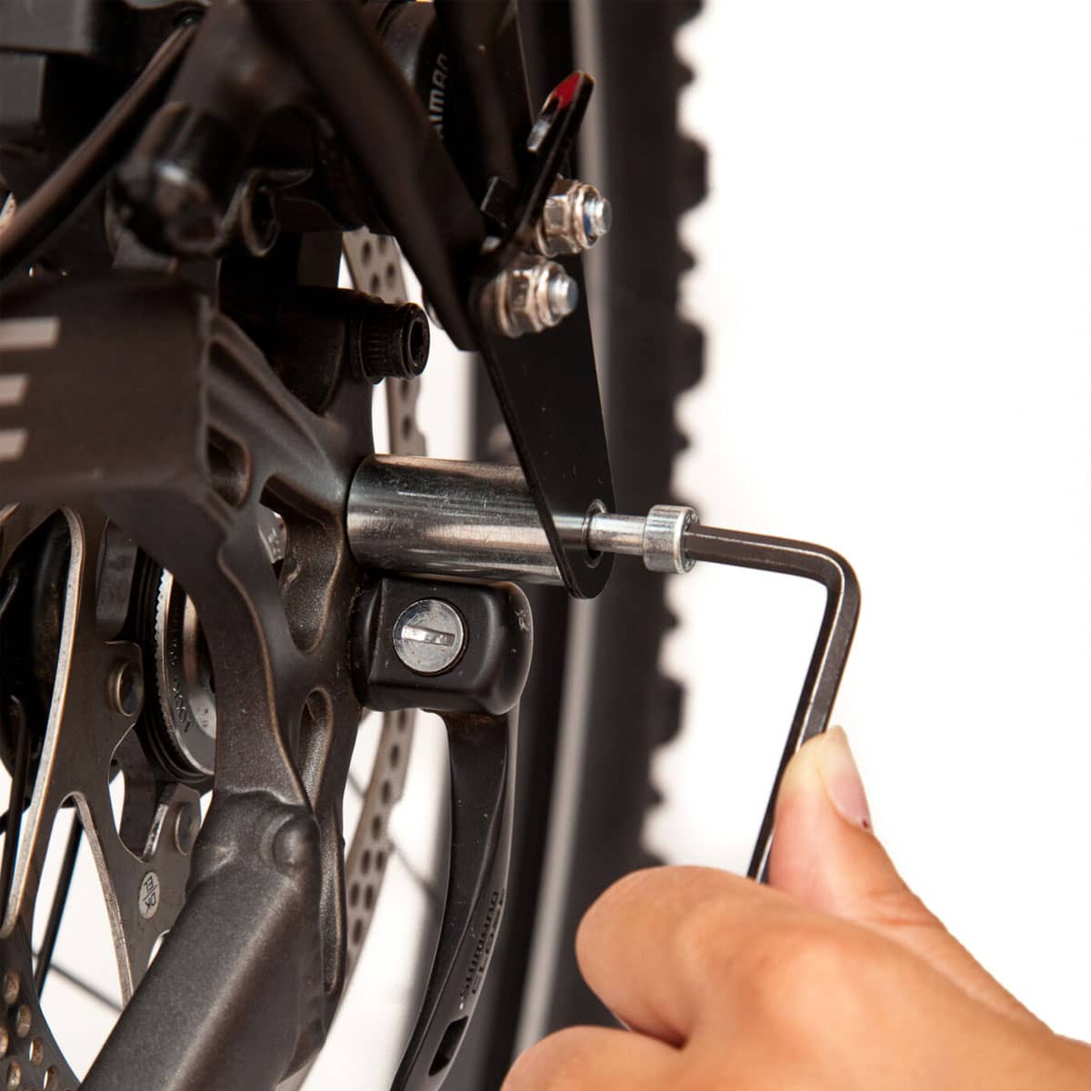 Zamontuj bagażnik za pomocą długiej śruby z zestawu adaptera i zabezpiecz nakrętką za ramą, jak pokazano na rysunku.